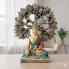 Decorative Buddha statue in colorful robes seated under a stylized Bodhi tree with detailed leaves.