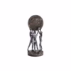 Decorative sculpture of three human figures lifting a textured globe, placed on a wooden table in a modern living room setting, symbolizing teamwork and unity.