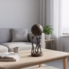 Decorative sculpture of three human figures lifting a textured globe, placed on a wooden table in a modern living room setting, symbolizing teamwork and unity.